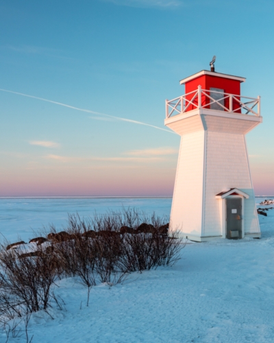 Summerside Lighthouse next to boardwalk at sunset in winter