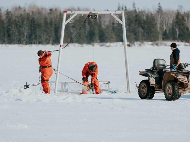 Three fishers on ice for winter mussel harvest