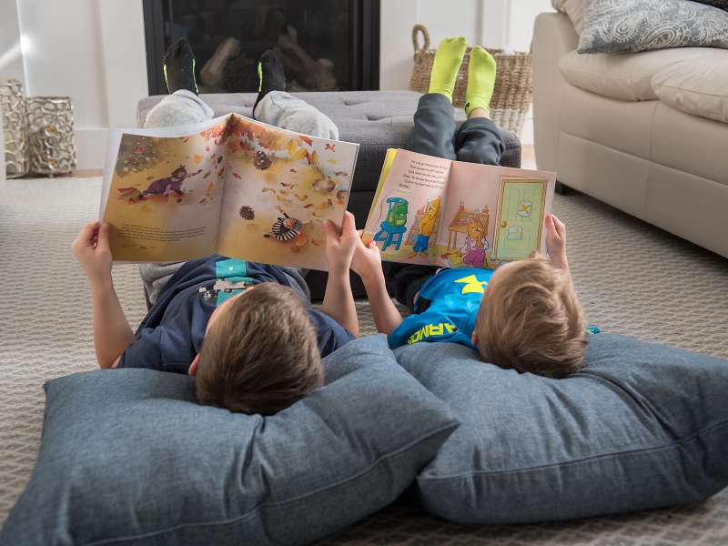 Two children lying on floor reading