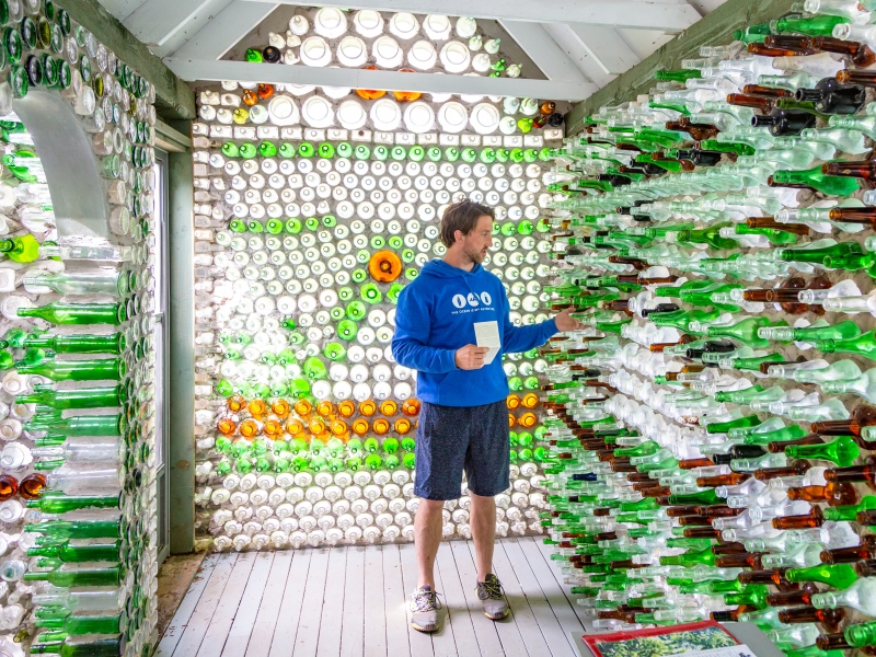 Person inside chapel admiring colourful glass bottles