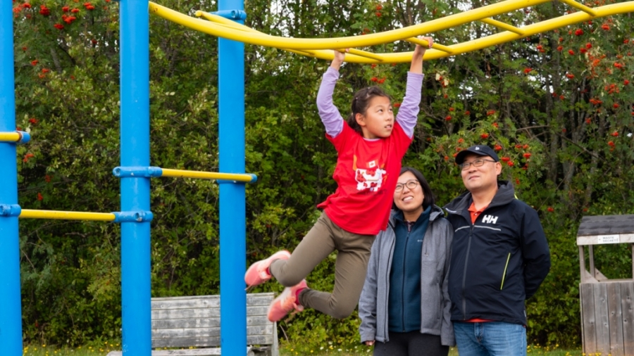 Family with child in playground, Prince Edward Island, Canada