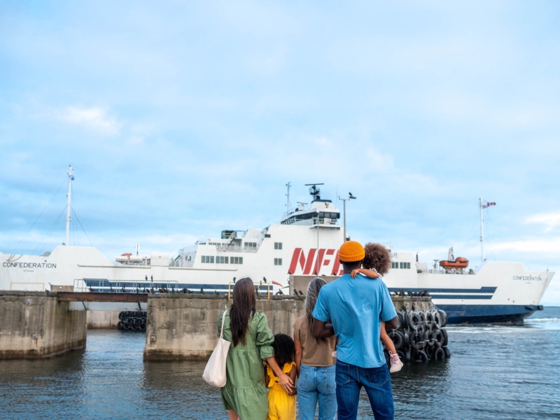 Two adults and three children watch a NFL ferry depart from PEI